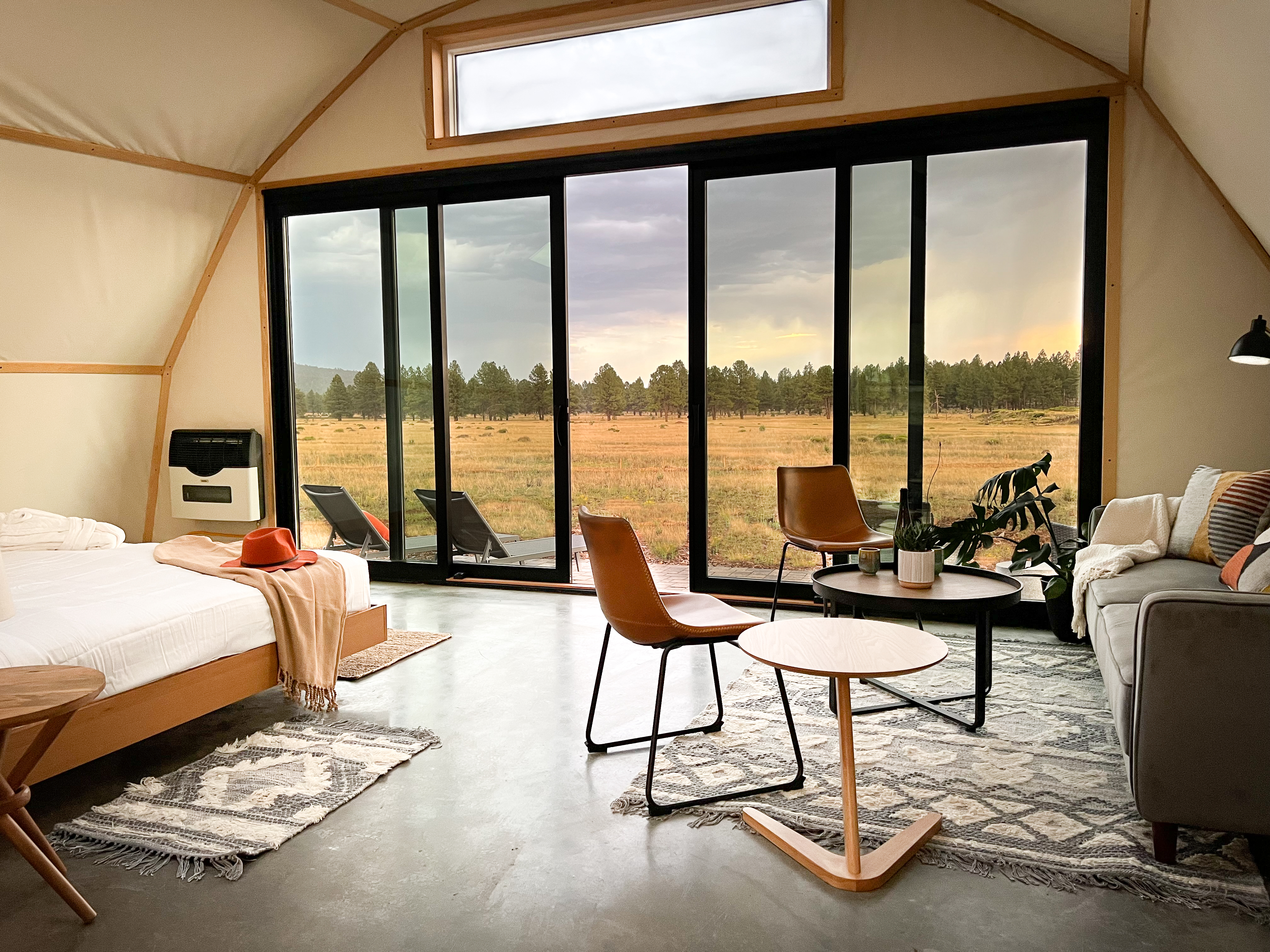 Interior of a Backland luxury glamping tent with bed and other modern furniture.