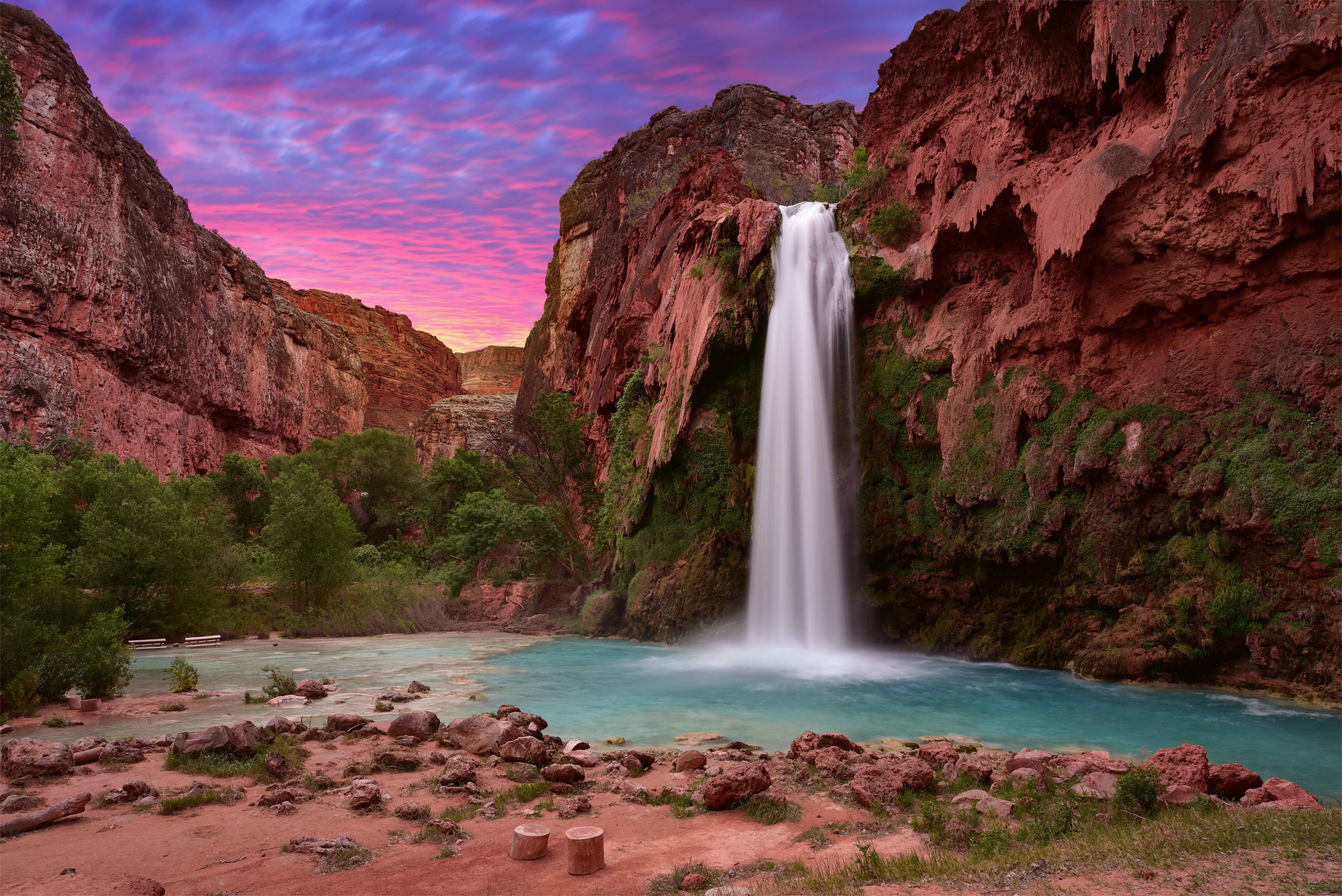 Havasu Falls waterfall with blue-green pool at sunset